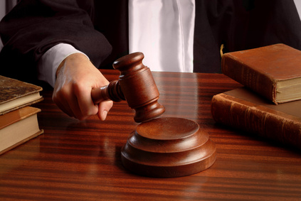 a judge hand striking a gavel over a table